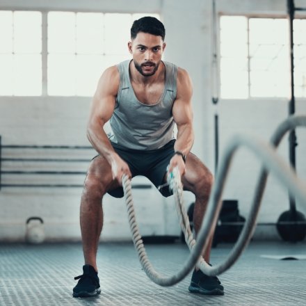 fit man with fit ropes in a gym