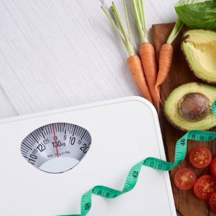 scale next to veggies, fruits and measuring tape