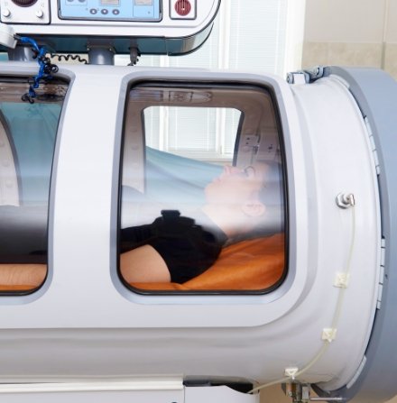 person increasing oxygen delivery inside a pressure chamber