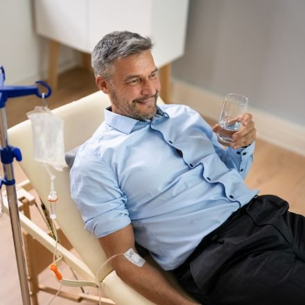 Happy man laying down while receiving iv therapy